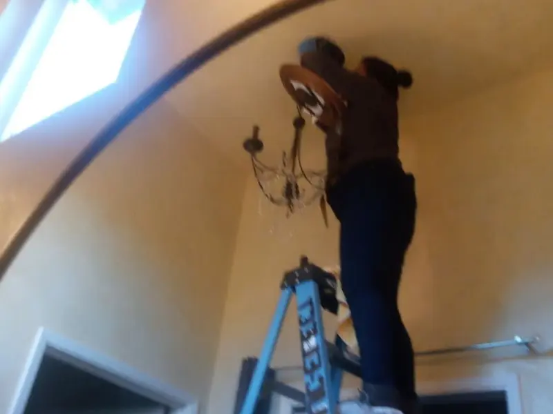 Electrician installing a chandelier in a Page residence